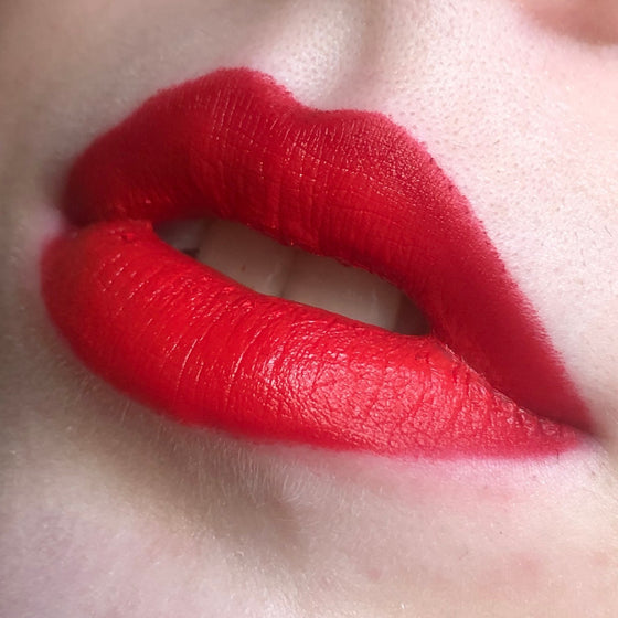 A close up of lips with a model wearing Courage Semi-Matte Lipstick
