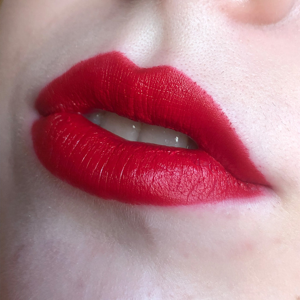 A close up of lips with a model wearing Courage Semi-Matte Lipstick