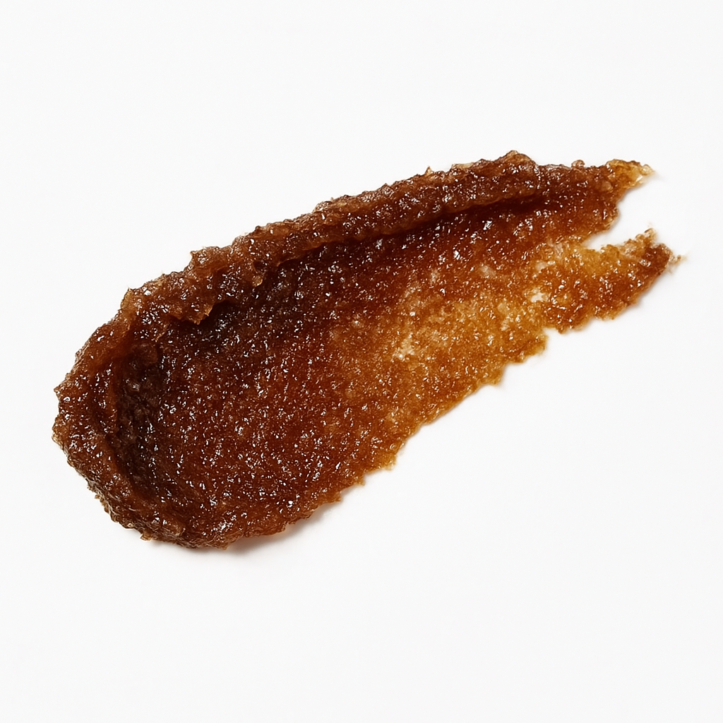 A close-up of Lucky Chick’s Sweet Vanilla Sugar Lip Scrub swatched on a white background, showing its rich brown sugar texture and glossy exfoliating formula.