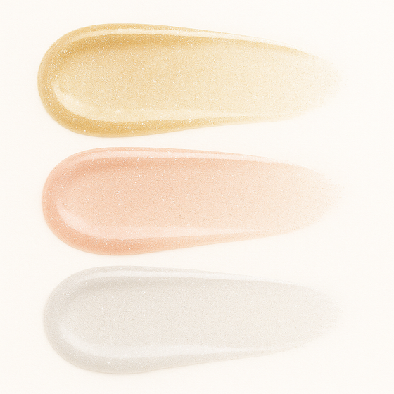 Three stacked swatches of Lucky Chick Shimmering Lip Glosses in Golden, Bubbly, and Shimmery—glossy, sparkly shades of gold, champagne peach, and silver—shown on a clean white background.
